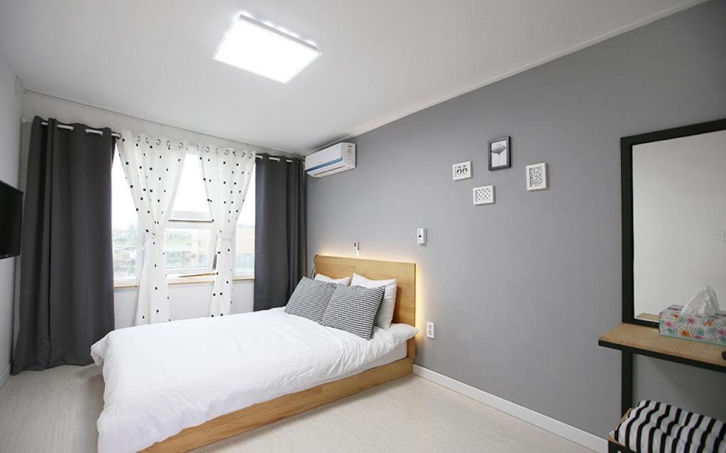 济州市MO Guesthouse的卧室配有白色的床和窗户。