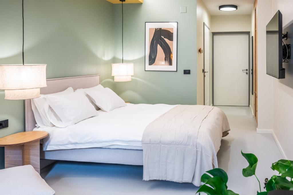 萨格勒布Superb Petrova Street Rooms的卧室配有一张白色的大床和一张桌子