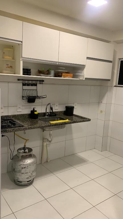 彼得罗利纳Aconchego的厨房配有白色橱柜和地板上的锅