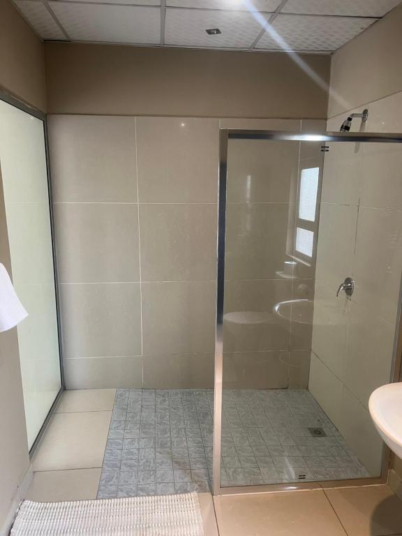 温当瓦Ondangwa Rest Camp的浴室里设有玻璃门淋浴