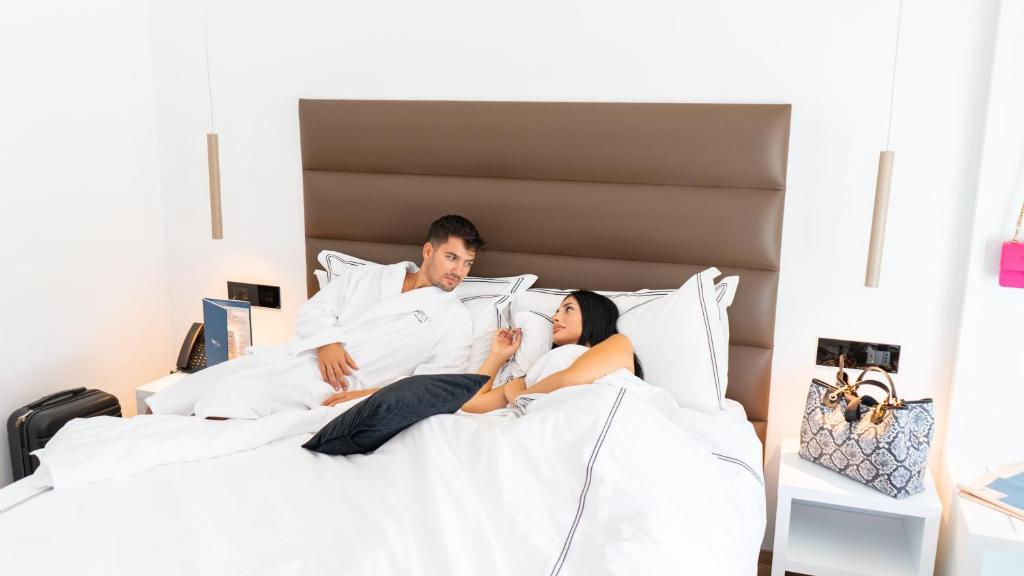 加利波利POPULA - The Lifestyle Hotel的躺在床上的男人和女人