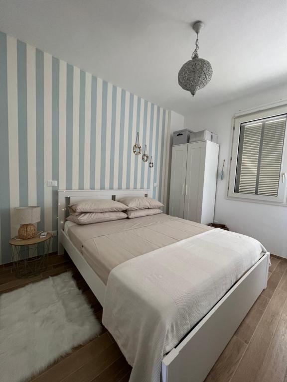 马里纳·迪·比萨Il Faro beach house的一间卧室设有一张大床和条纹墙