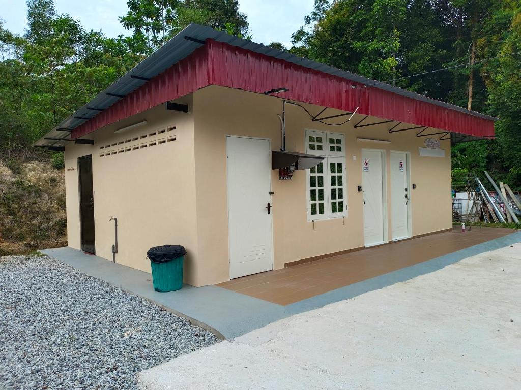 马兰ROOMSTAY NIMAZA Bilik 1的一个带红色屋顶和两个白色门的车库