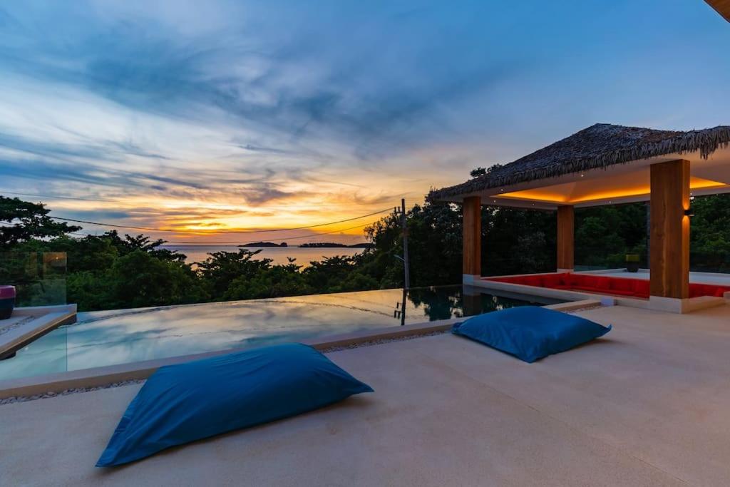 苏梅岛Villa Nirvana - Wonderful Sea View的露台上的日落美景和蓝色枕头