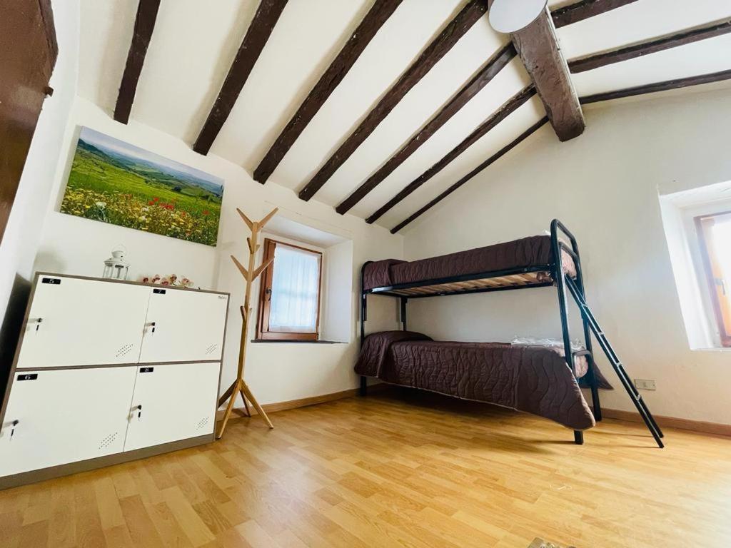 GuigliaCasa del Viandante Borgo dei Sassi di Roccamalatina的一间卧室配有双层床,铺有木地板