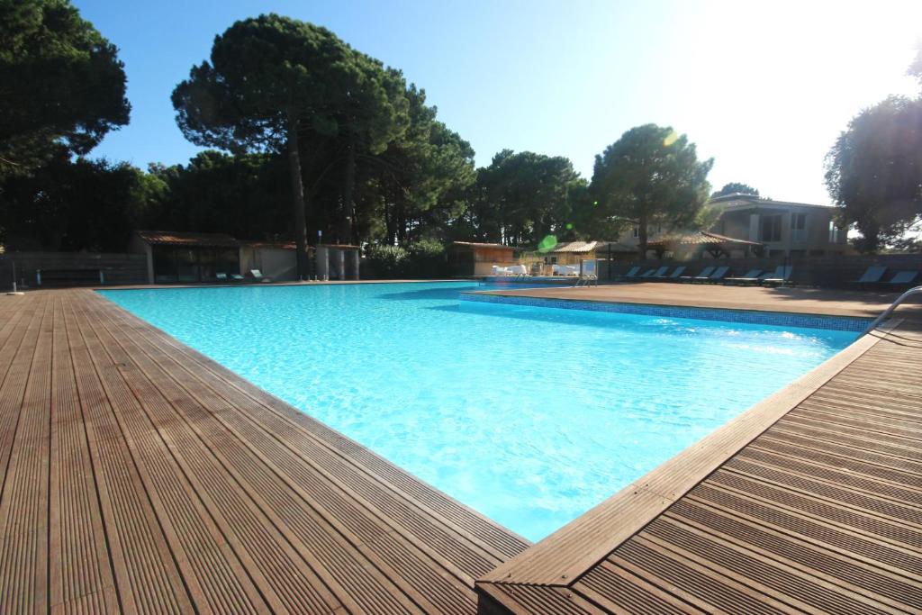 LecciStudio grande piscine dans résidence hôtelière, proche plage的一个带木制甲板的大型蓝色游泳池