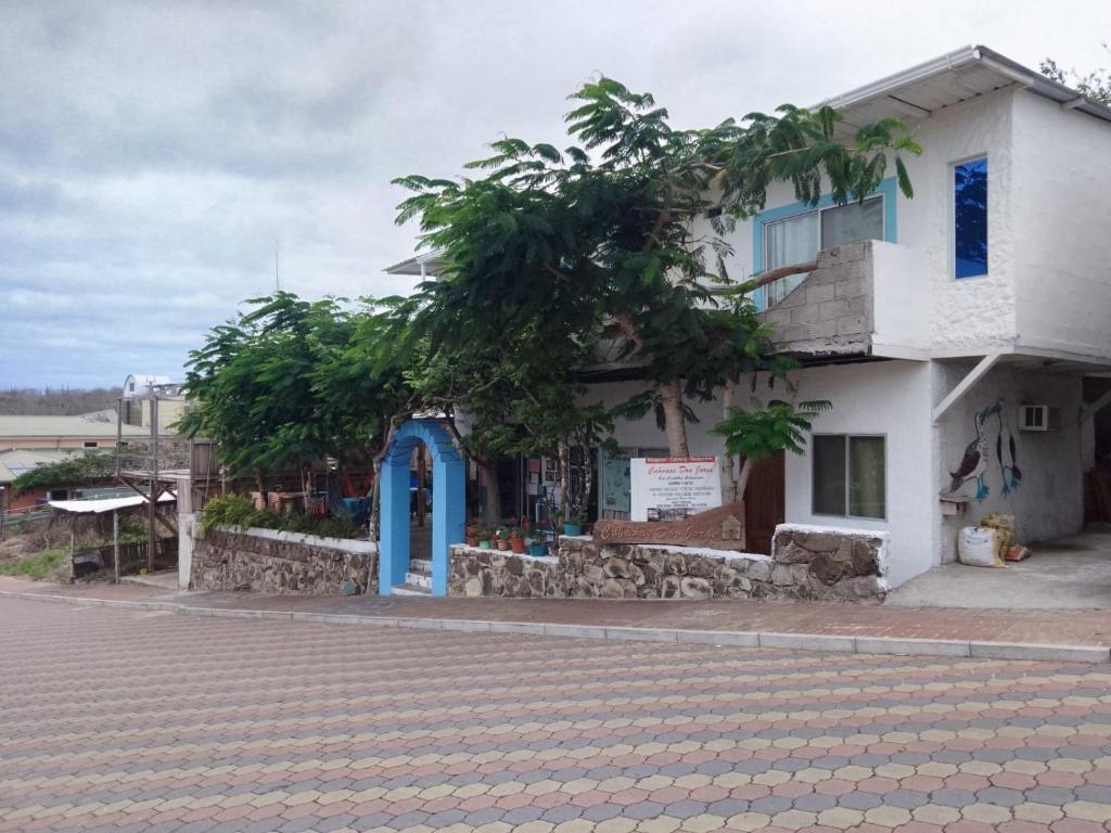 巴克里索莫雷诺港Hostal Cabañas Don Jorge的一条白色的建筑,在街上有一扇蓝色的门