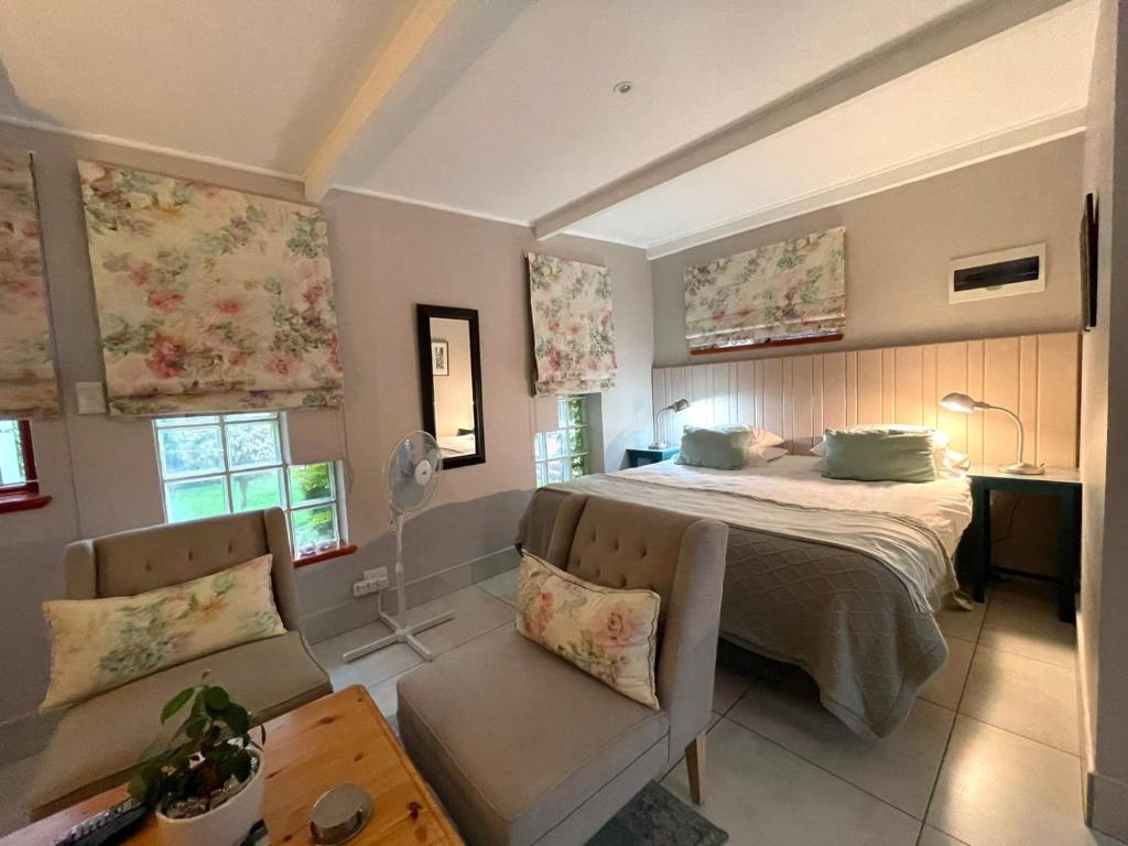 乔治EdenNook的一间卧室配有一张床、一张沙发和窗户。