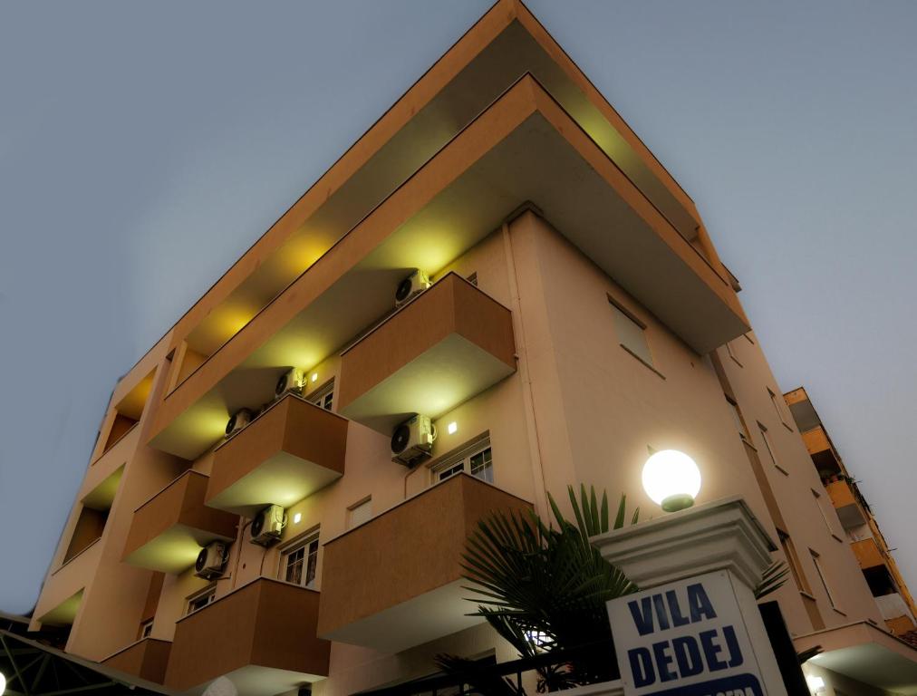 都拉斯Hotel Vila Dedej的前面有标志的高楼