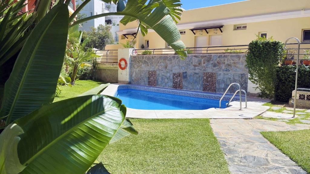 托雷德本纳贾尔邦Nuevo con Piscina y Parking en la Playa的一座房子旁的院子内的游泳池