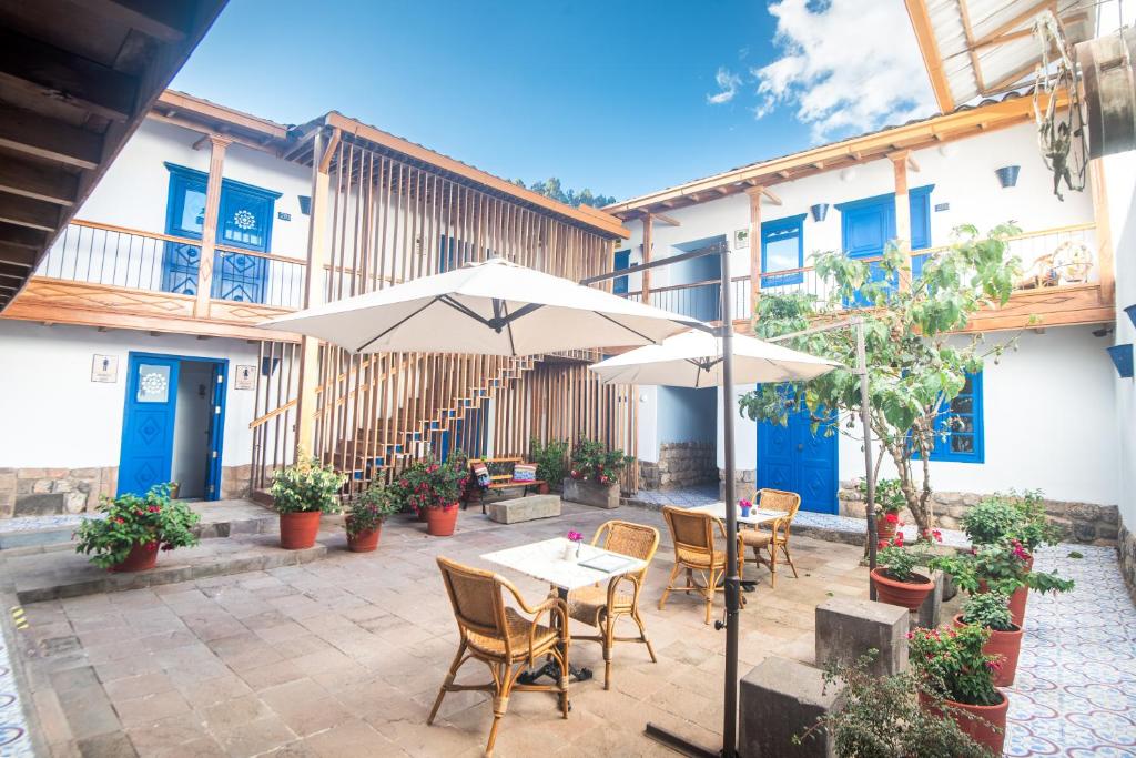 库斯科金塔圣布拉斯阿纳奈酒店的一个带桌椅和遮阳伞的庭院