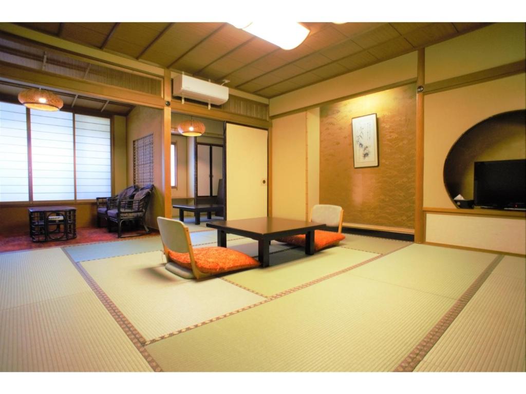 加贺Yamashiro Onsen Yuzankaku - Vacation STAY 86433v的配有桌椅和电视的客房