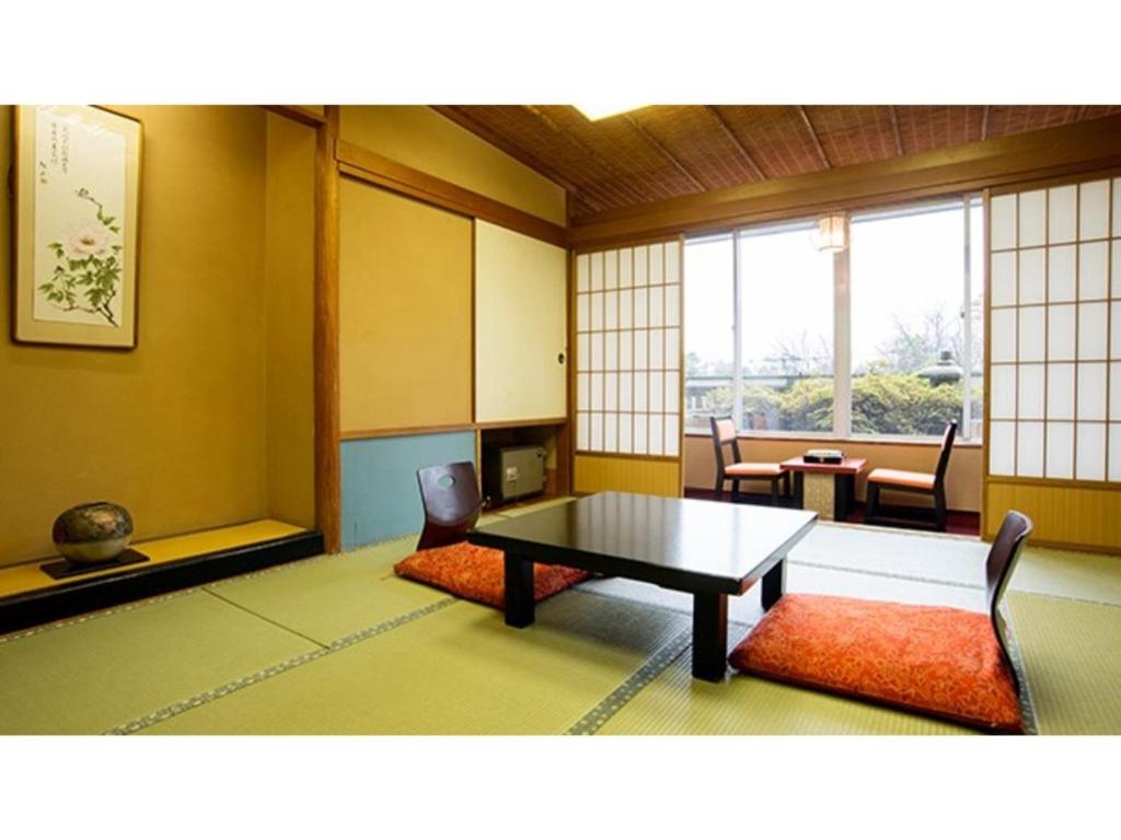 加贺Yamashiro Onsen Yuzankaku - Vacation STAY 86430v的客房设有桌椅和窗户。