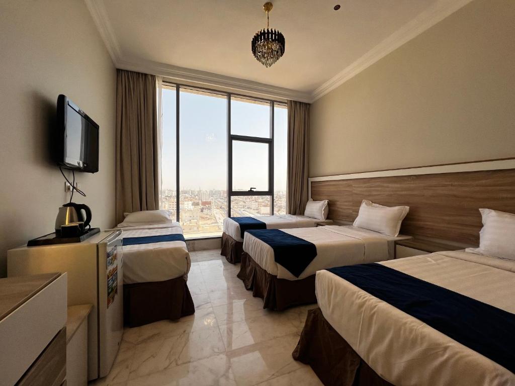 麦地那Taiba Karim Hotel Madina的酒店客房设有两张床和电视。