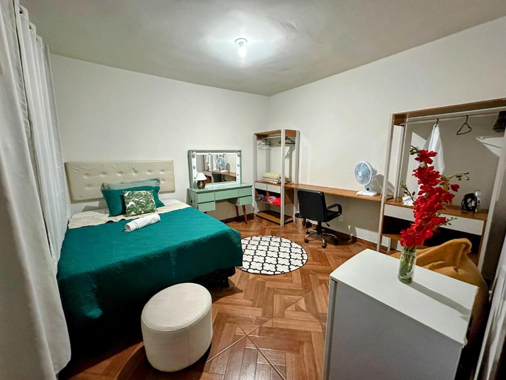贝洛奥里藏特Espaço Nill的一间卧室配有一张绿色的床和一张书桌