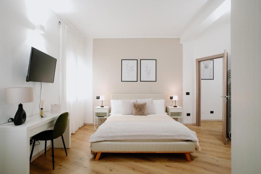 维罗纳Alatea Apartments Valverde的白色卧室配有床和书桌