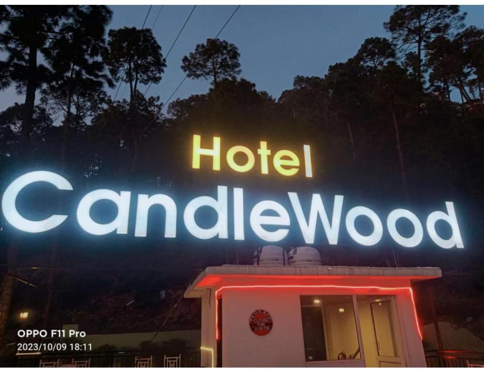 西姆拉Hotel Candle Wood, Shimla的标牌在酒店的camaldwell标志上
