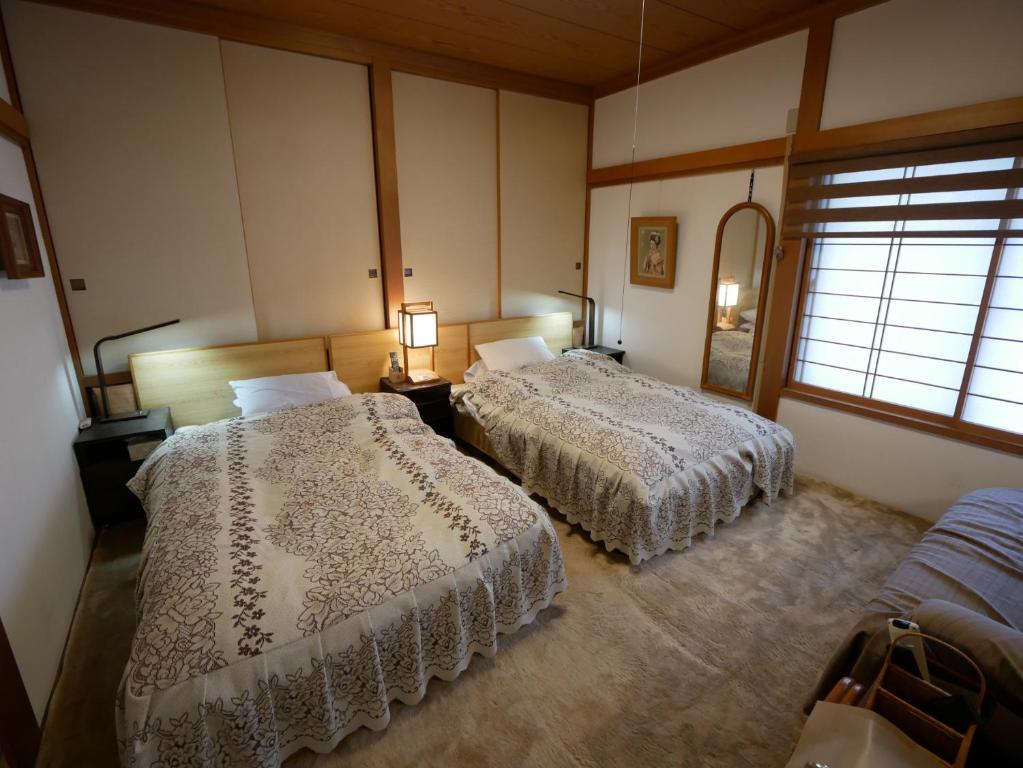 佐渡市Natural Mind Tour guest house - Vacation STAY 23292v的一间卧室设有两张床和窗户。