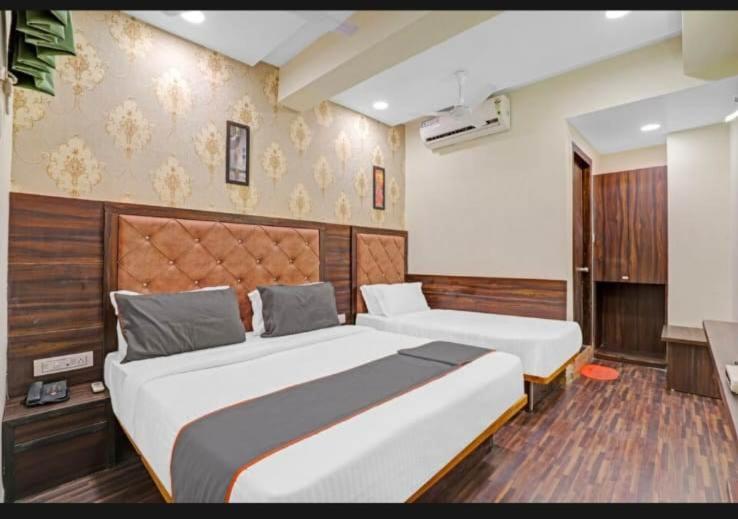 艾哈迈达巴德HOTEL STAY INN的酒店客房配有两张床和一张书桌