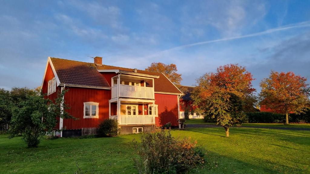 AnebyLantligt hus på Knohult的一座位于庭院内的大型红色房屋,设有阳台