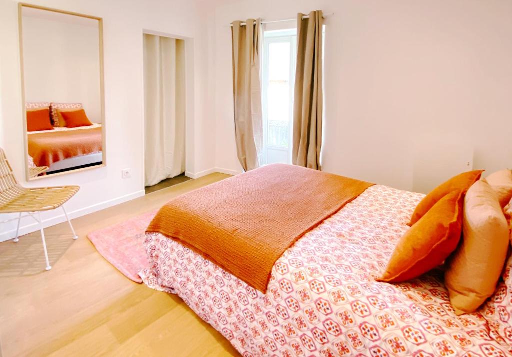 DéolsLe Bohème ⸱ Stationnement gratuit ⸱ Fibre的一间卧室配有一张床、一把椅子和镜子