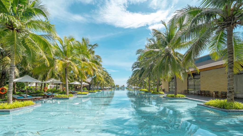 绥和市Rosa Alba Resort & Villas Tuy Hoa的度假村内棕榈树游泳池