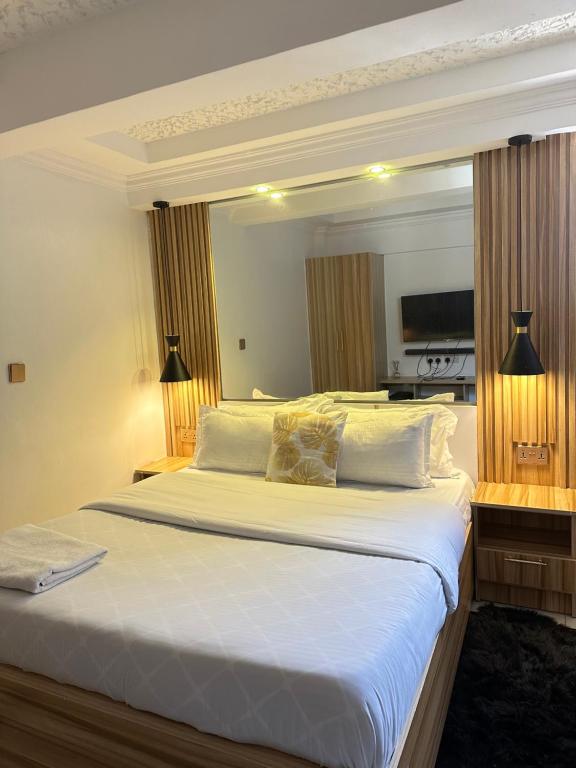 埃尔多雷特Regency Homes II的卧室配有一张带白色床单和枕头的大床。