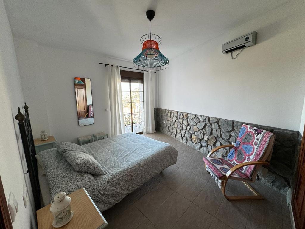 贝瑙卡斯apartamento arroyo的卧室配有床、椅子和窗户。