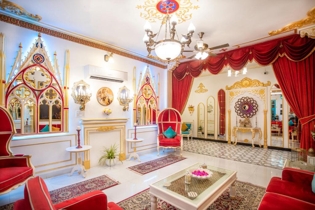 斋浦尔The Royal Hermitage - Best Luxury Boutique Hotel Jaipur的客厅配有红色椅子和吊灯。