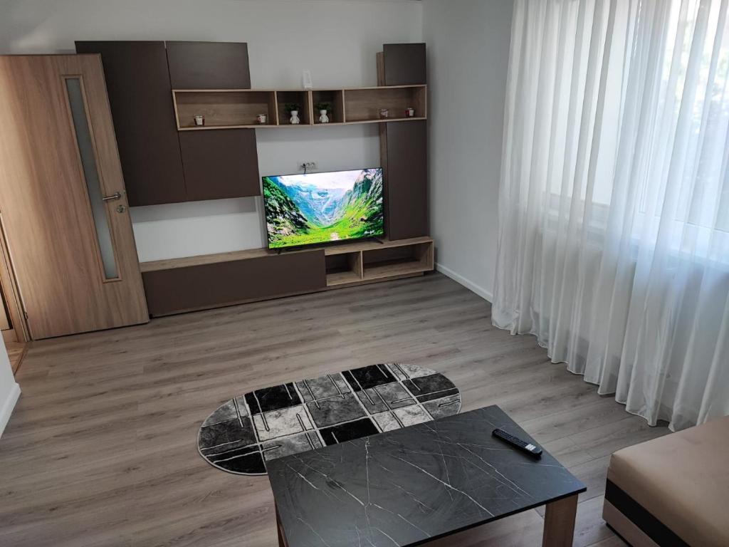皮亚特拉-尼亚姆茨A&A Residence的客厅配有桌子和平面电视。