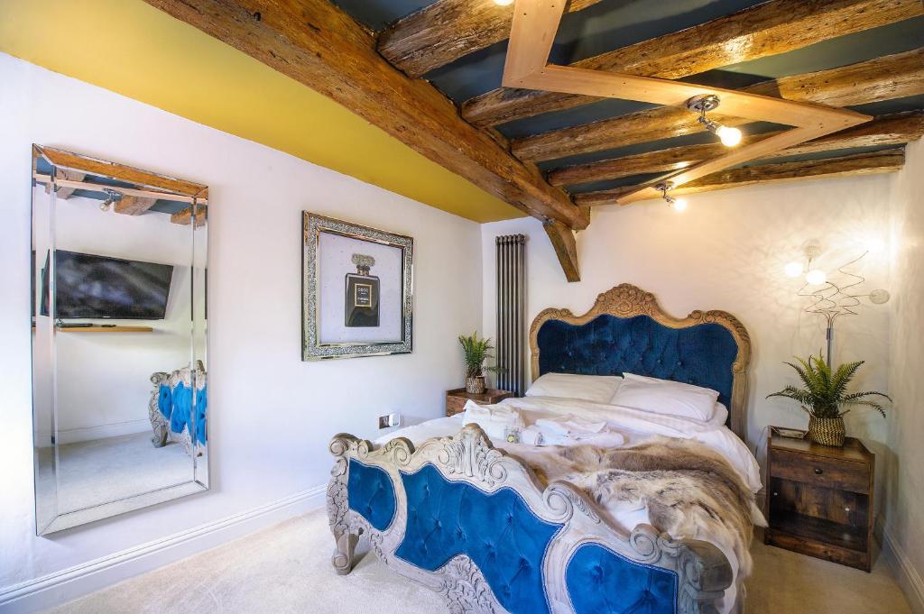 萨弗伦沃尔登King Suite In 600 Year Old Manor House In Saffron Walden North Essex的一间卧室配有蓝色的床和镜子