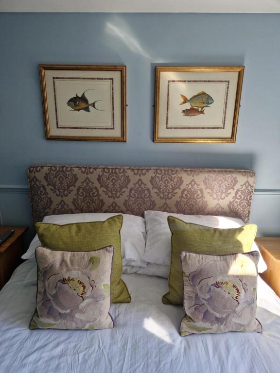 埃姆斯沃思The Emsworth B&B Hotel的卧室配有一张墙上有两张照片的床。