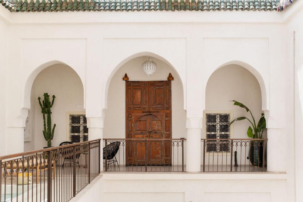 马拉喀什Riad La Lumière d'Étoile的白色建筑中设有拱门的大木门