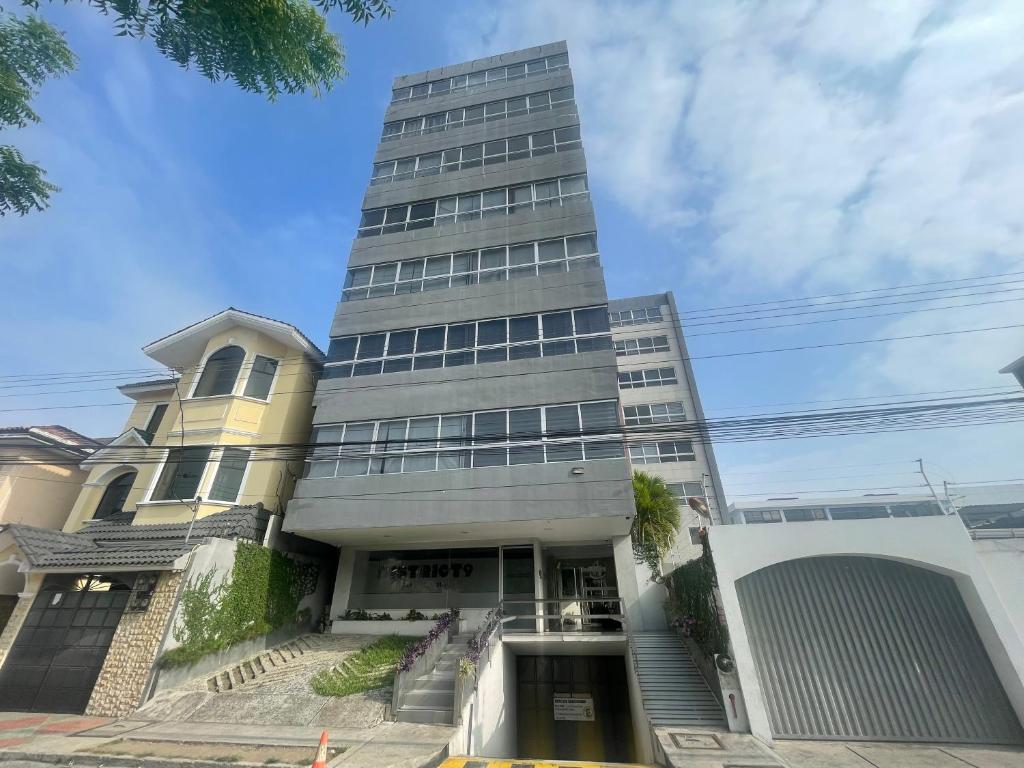 瓜亚基尔Five Stars Suites - Kennedy - Guayaquil的一座高大的建筑,有楼梯通往