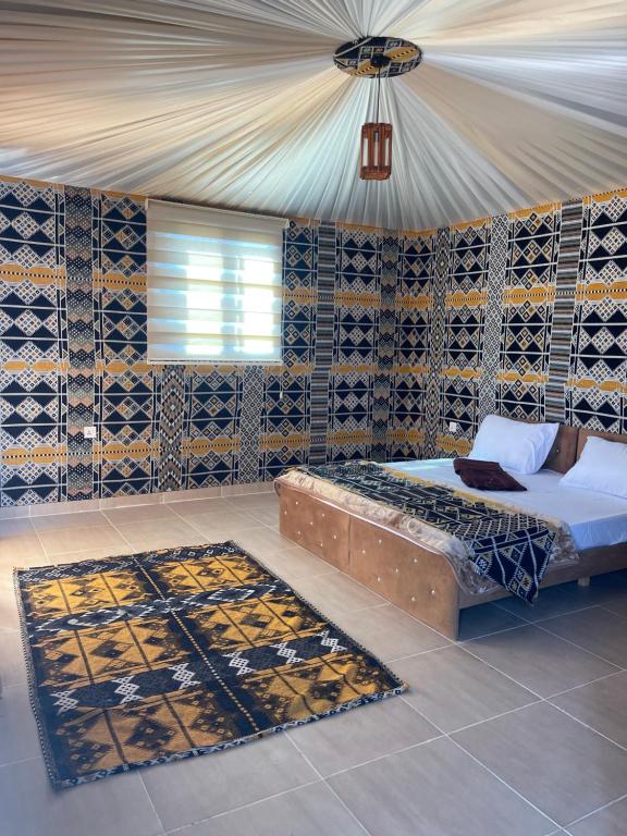 瓦迪拉姆Wadi Rum Star Camp的一间卧室配有一张床和地毯