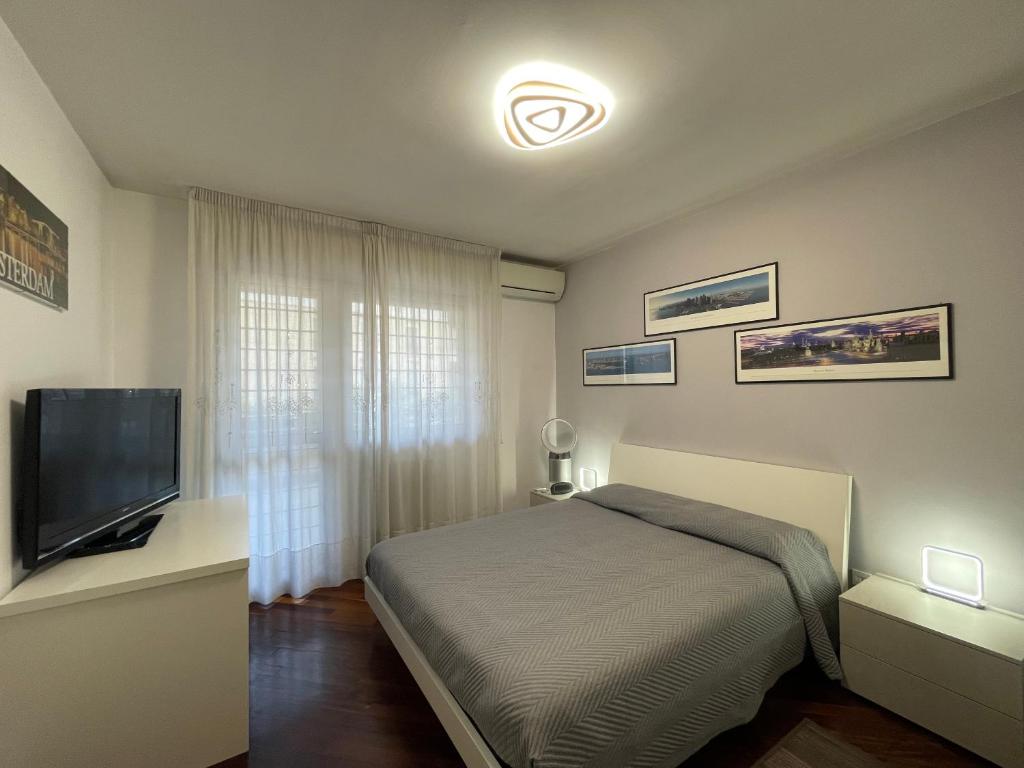 罗马Stanza Eur Tintoretto的一间卧室配有一张床和一台平面电视