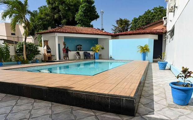博阿维斯塔Barrudada Palace Hotel-Boa Vista的一座带木甲板的游泳池,位于一座房子旁边