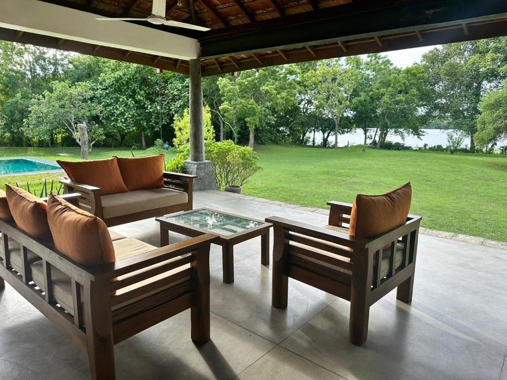NikaweratiyaMagalle Wewa Villa的一个带桌椅的庭院和一个游泳池