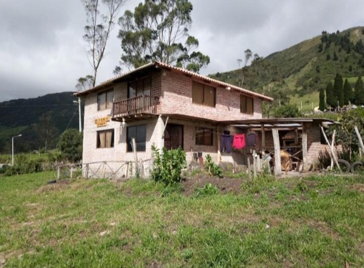 ChamboMIRADOR MAMÁ NATY Y SUS NEGUITOS的田野上山丘上的一座老房子
