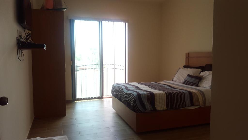 伊拉普阿托ORQUIDEA的一间卧室设有一张床和一个滑动玻璃门
