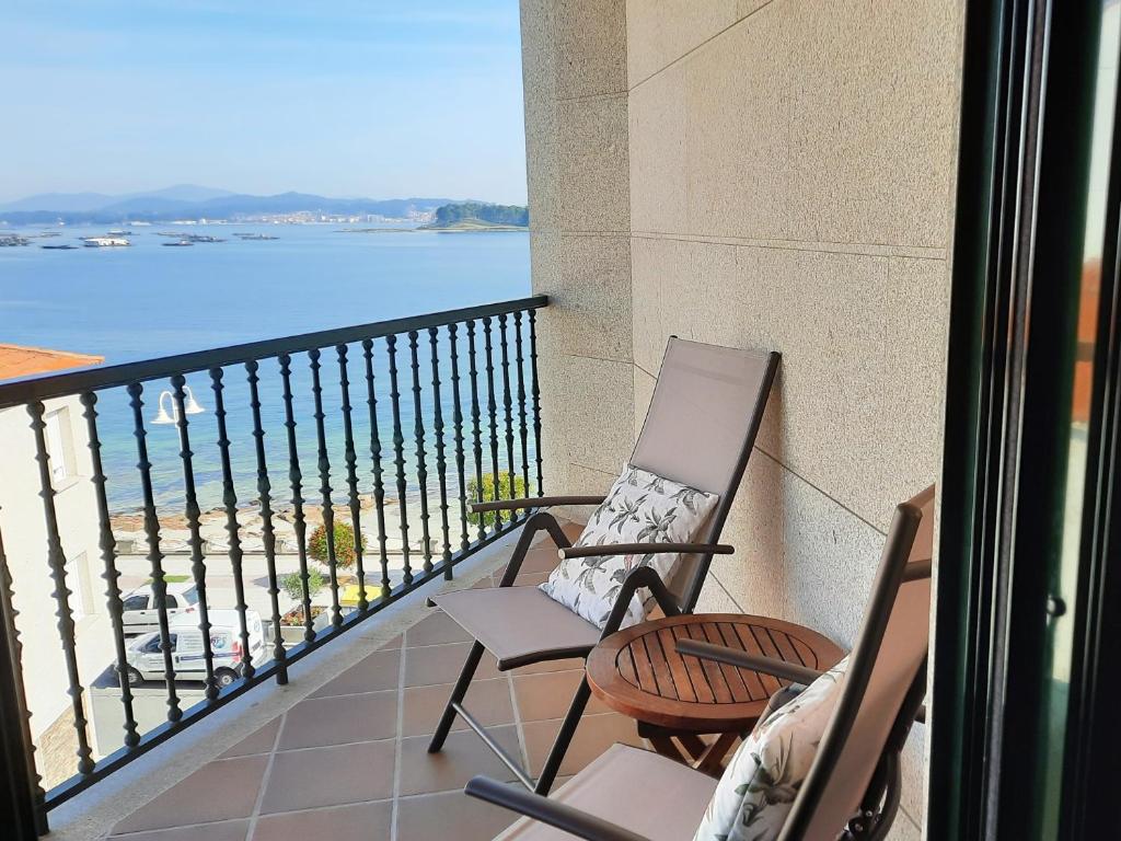 格罗韦Apartamento en Beiramar的阳台上配有两把椅子,享有水景