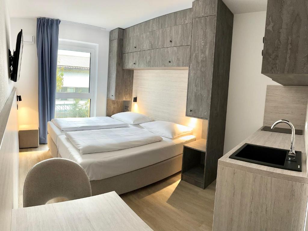 安达赫治Apartimo München-Unterhaching的酒店客房设有床和水槽