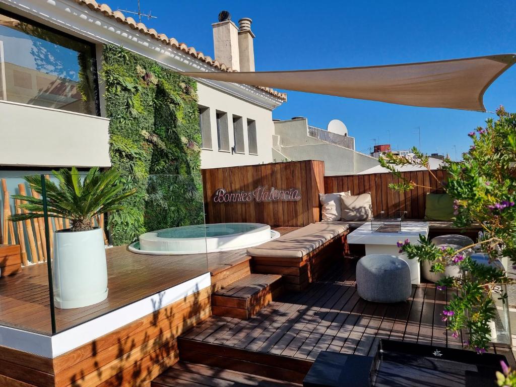 瓦伦西亚BONNIES Suites & Spa Valencia的户外庭院配有沙发和桌子
