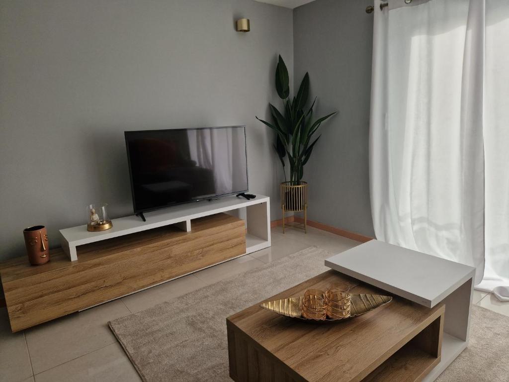 普拉亚Aconchegante Refúgio Beira-Mar的客厅配有台面上的平面电视