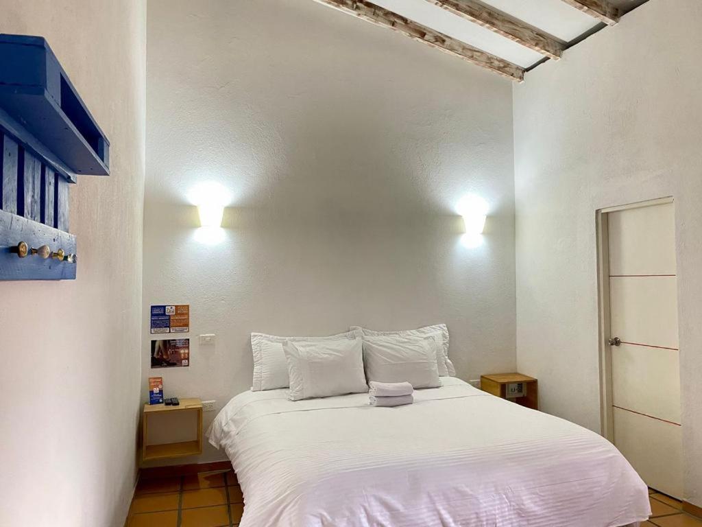 波哥大Zana Hotel Boutique的卧室配有一张带两个枕头的大白色床