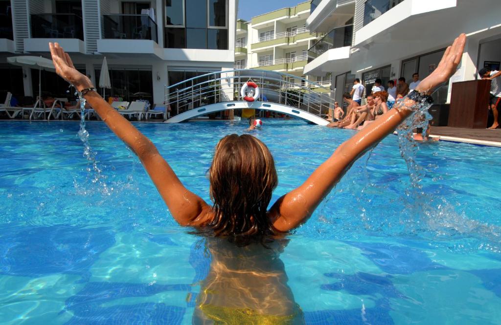 阿拉尼亚奥巴星辰酒店 - 超级全包的水中一个手臂在游泳池里的女人