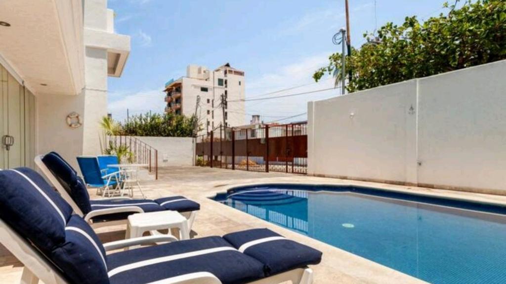 阿卡普尔科Hermoso Departamento Nuevo的一个带躺椅的游泳池和一个游泳池