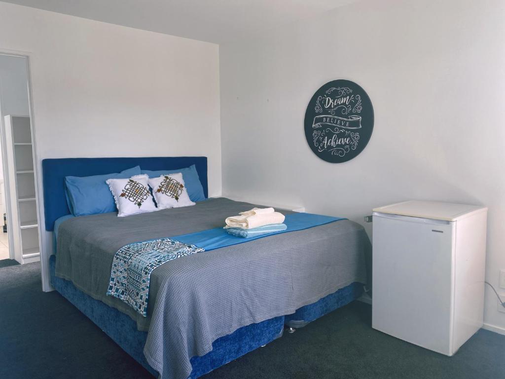 奥克兰A private Large master room with en-suite的卧室配有蓝色的床,墙上挂着黑板