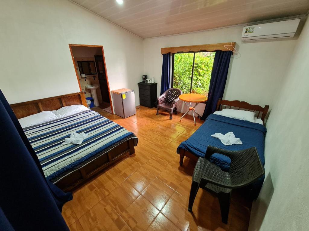 德雷克Osa Corcovado Lodge的一间卧室配有两张床、一张桌子和一把椅子