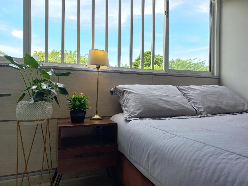佛罗里达布兰卡Moderna y confortable habitación的一间卧室配有一张床和一张带台灯的桌子